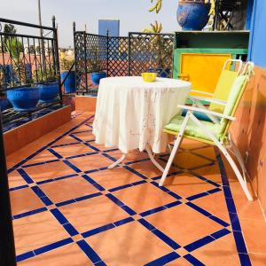 ALMARKAB Riad في مراكش: طاولة وكراسي على شرفة مع أرضية زرقاء وبيضاء