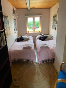 two beds in a room with a window at Drömhus på Österlen in Glemminge