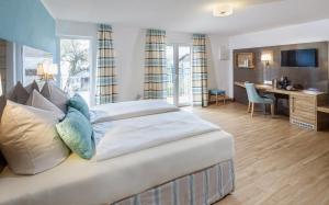 Hotel Schönau في لينداو: غرفة نوم مع سرير كبير مع مكتب ومكتب
