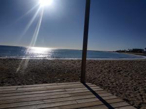 Acogedor adosado muy cerca de la playa في ألمازورا: عمود على الشاطئ مع الشمس في السماء