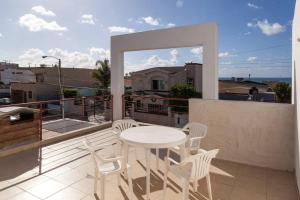een witte tafel en stoelen op een balkon bij Sunset Included in your stay !!! in Tijuana