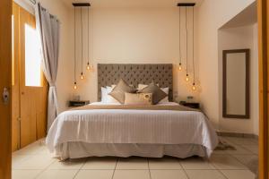 Un dormitorio con una gran cama blanca y una ventana en ArcoSodi Hotel Boutique en Oaxaca de Juárez