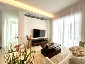 a living room with a couch and a flat screen tv at Premium Ferienwohnung: Allegra - Alba - Residential in Ciudad Quesada
