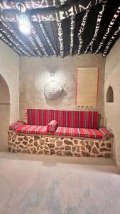 a room with a red bench in a wall at Alqalah Inn in Al Ḩamrāʼ