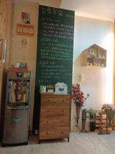 a menu on a wall in a kitchen with a refrigerator at 愛海居民宿Love in Taitung City