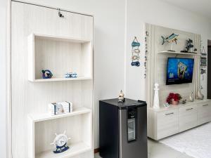 a black refrigerator in a room with white shelves at Estada inesquecível 09 Bacutia/Guarapari Premium in Guarapari
