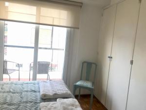 1 dormitorio con cama, ventana y silla en Apartment in Recoleta Buenos Aires next to an Embassy en Buenos Aires