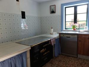 cocina con fogones, fregadero y ventana en Casas de Maragouzos, en Silleda