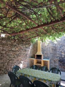 una mesa y sillas en una habitación con una pared de piedra en Casas de Maragouzos, en Silleda