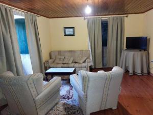 a living room with two chairs and a couch and a table at Casas de Maragouzos in Silleda