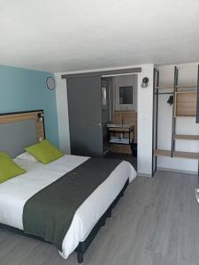 a bedroom with a large bed and a bathroom at Campanile Saumur in Saumur