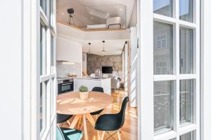 a kitchen and dining room with a table and chairs at Cedofeita Balcony in Porto