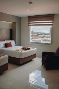 a bedroom with a large bed and a window at Hotel Dali Plaza Ejecutivo in Guadalajara