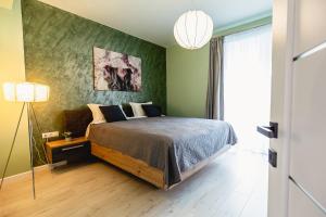 a bedroom with a bed and a green wall at Alice apartment in Sibiu