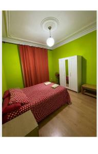 ein Schlafzimmer mit einem roten Bett und grünen Wänden in der Unterkunft Barcelona Centric in Barcelona