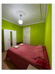 Un dormitorio con una cama roja con paredes verdes en Barcelona Centric en Barcelona