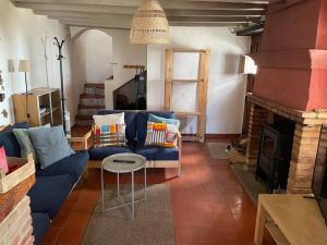 Jubrique的住宿－Casa Isabel, naturaleza y descanso en la serranía.，客厅设有蓝色的沙发和壁炉