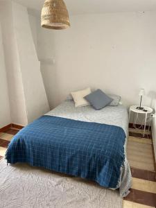 - une chambre avec un lit et une couverture bleue dans l'établissement Casa Isabel, naturaleza y descanso en la serranía., à Jubrique