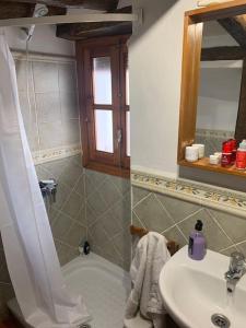 uma casa de banho com um lavatório, um chuveiro e uma banheira em Casa Isabel, naturaleza y descanso en la serranía. em Jubrique