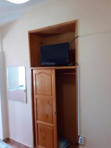 Cette chambre dispose d'une télévision au-dessus d'une armoire. dans l'établissement Квартири - стаи за гости, Ахтопол, à Ahtopol