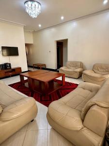 a living room with couches and a wooden table at Makanga Hill Suites in Kabale