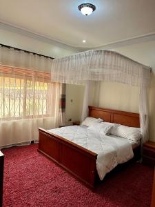a bedroom with a large bed with a canopy at Makanga Hill Suites in Kabale