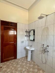 a bathroom with a sink and a shower and a toilet at Makanga Hill Suites in Kabale