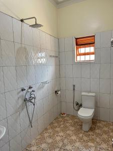 a bathroom with a toilet and a sink at Makanga Hill Suites in Kabale