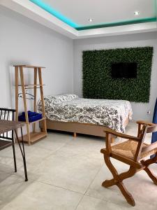 a bedroom with a bed and a green wall at Acogedor departamento monoambiente a metros de la playa in Rada Tilly