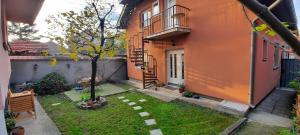 een kleine tuin met een boom voor een gebouw bij Apartman Carpe Diem in Zaječar