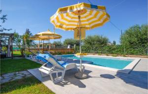 a pool with two umbrellas and two chairs and a table at 2 Bedroom Beautiful Home In Corridonia in Corridonia +25 photos