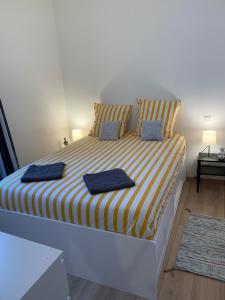 a bedroom with a large bed with yellow and white stripes at Biarritz centre bel Apt 2 pièces rue calme in Biarritz