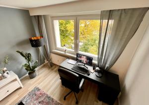 a desk with a computer in a room with a window at KMHosting Modern Apartment Zentrum - Wohlfühlen & Arbeiten in Chemnitz