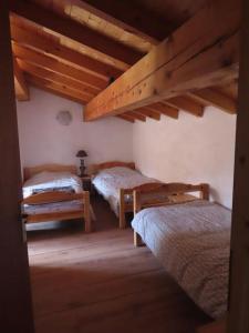 1 dormitorio con 2 camas en una habitación con techos de madera en Authentique Maison de Village Savoyarde, en Saint-Martin-de-Belleville