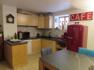 a kitchen with a red refrigerator and a table at Authentique Maison de Village Savoyarde in Saint-Martin-de-Belleville +26 photos