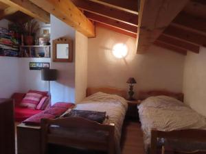 1 dormitorio con 2 camas y sofá en Authentique Maison de Village Savoyarde, en Saint-Martin-de-Belleville