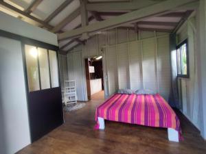 um quarto com uma cama rosa num quarto em Coco et Cajou Bungalows em Sainte-Anne