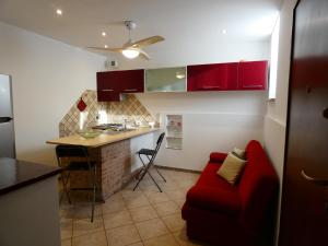 a kitchen with red cabinets and a red couch at Le dimore di Esiodo in Rome