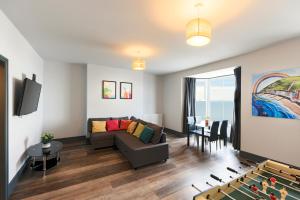 ein Wohnzimmer mit einem Sofa und einem Tisch in der Unterkunft Seafront apartment with balcony, parking and sea views in Aberystwyth