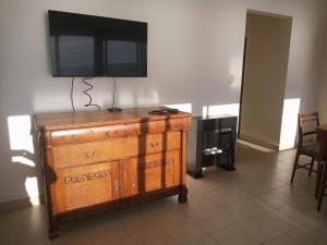 a television on a wall above a wooden dresser at Radar Mirador Cabo Corrientes in Mar del Plata