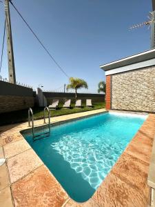 a swimming pool in front of a building with a windmill at Funtastic Villa With Pool in Albufeira