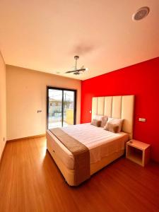 a bedroom with a large bed with red walls at Funtastic Villa With Pool in Albufeira +19 photos