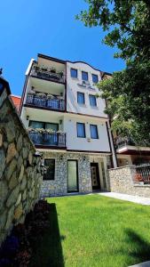 um grande edifício branco com uma parede de pedra em Vila Ivica Kjoshe em Ohrid