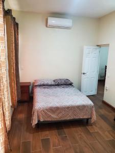 um pequeno quarto com uma cama e uma porta em Departamento ELSA. La Crucecita, Huatulco. em Santa Cruz, Huatulco