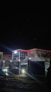 un edificio di notte con luci davanti di Oak Suites & Bar a Benin City