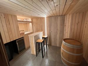 una habitación con un barril y dos taburetes en una sauna en Gîte Chez Doumé, en Houffalize