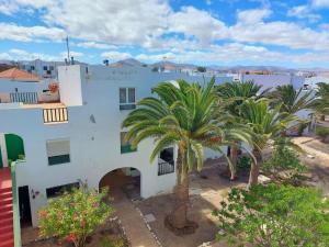 een wit gebouw met palmbomen ervoor bij Casa Azul in Costa de Antigua