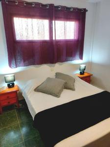 een slaapkamer met een bed met twee lampen en een raam bij Casa Azul in Costa de Antigua