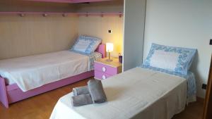een slaapkamer met 2 bedden en een tafel met een lamp bij La casa di Panfilo in Sulmona