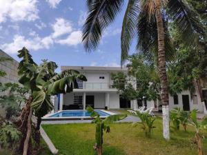 uma casa com uma piscina e uma palmeira em CASA DYA em Cozumel